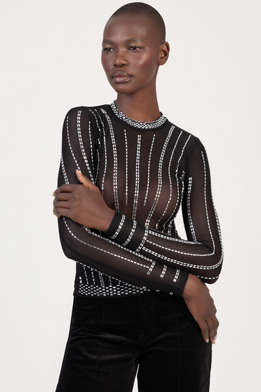 black sheer long sleeve top with white dotted stripes and beaded neckline, worn by a model.