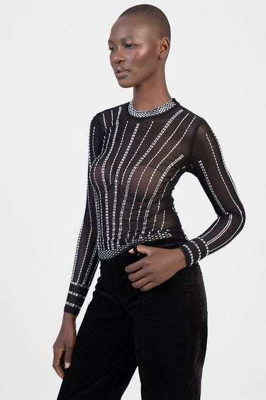 sheer black long sleeve top with white dotted stripes and beaded neck, paired with black pants