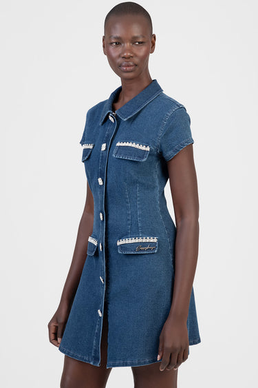 woman in a blue denim dress with short sleeves, collar, front button placket, and pearl trim on pocket flaps