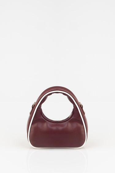 burgundy leather mini bag with white piping and rounded handles on a white background