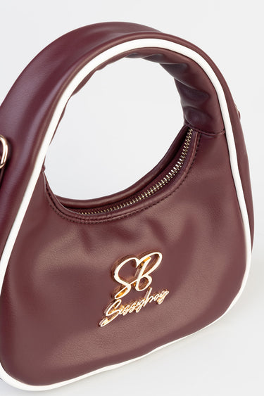 burgundy handbag with white piping, gold zipper and a gold script logo on the front