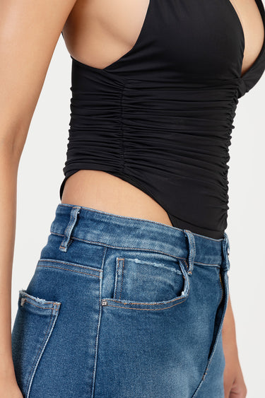 black ruched sleeveless top worn with blue denim jeans