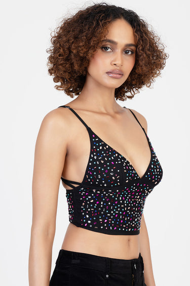 woman wearing a black cropped top with multicoloured bead embellishments and thin straps