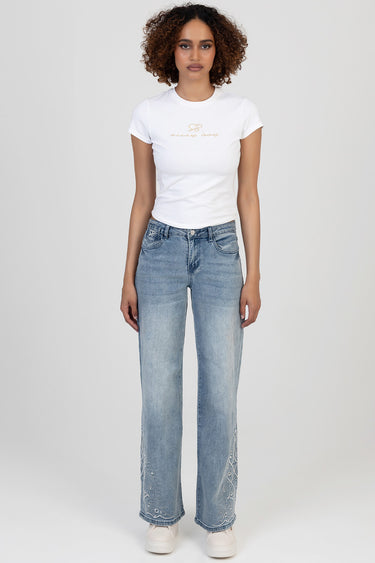 woman model in white tee and light wash wide leg jeans with decorative embroidery at the hems