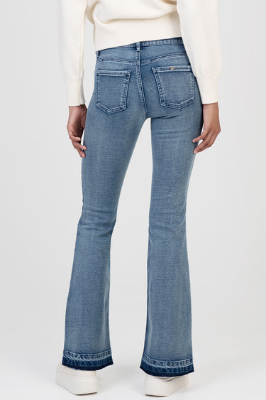 back view of light blue flare leg jeans with rear pockets and contrast stitching, paired with a white knit sweater