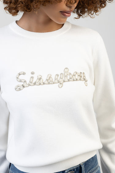 white knit sweater with rhinestone cursive lettering across the chest