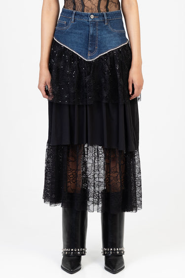 woman wearing a two tone midi skirt with denim waist and black lace and tulle layers, paired with black heeled boots