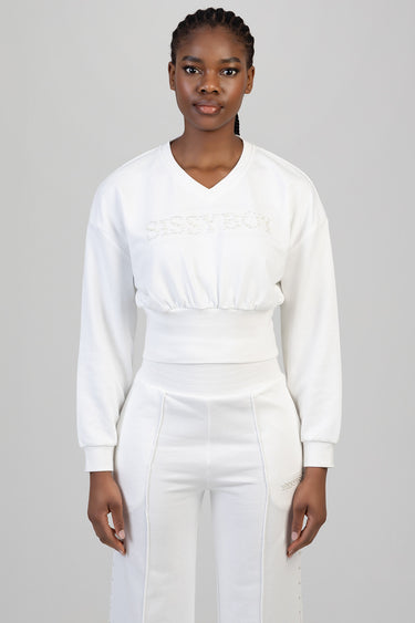 woman wearing a white long sleeve cropped sweatshirt with a gathered waist, paired with white high waisted joggers