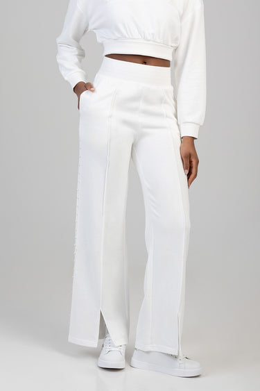 white sweatpants with pearl trim along the side seam, wide leg, high waist worn with sneakers