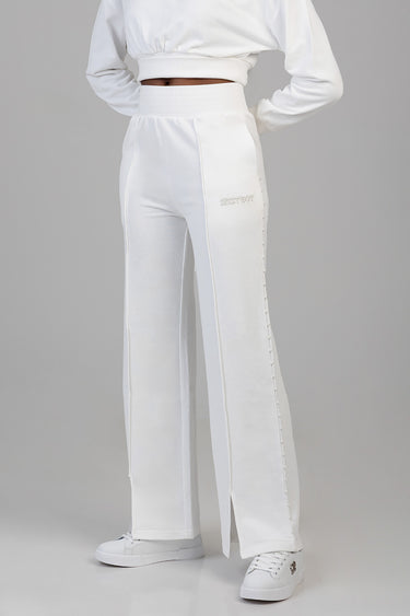 white sweat pants with a high waistband and wide leg, features a row of small studs along the outer seam