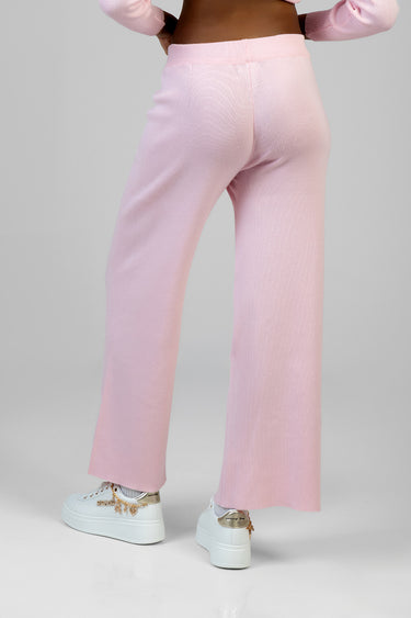 pink knit wide leg pants shown from behind on a model with an elastic waist and textured fabric