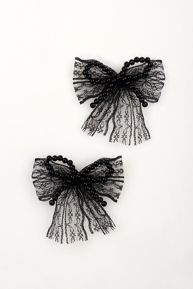 two black lace bow charms with beaded loops on a white background