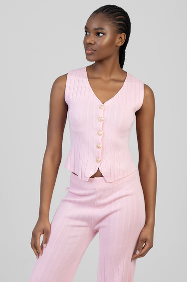 woman wearing pink ribbed knit waistcoat with gold buttons and matching pants