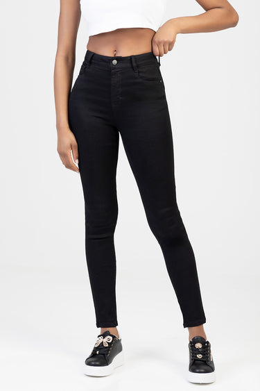 woman wearing black skinny jeans with a white cropped top and black sneakers with white soles