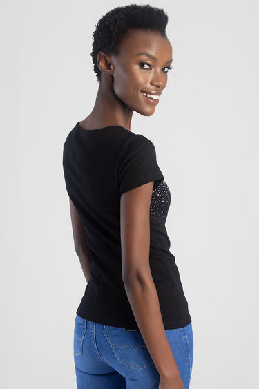 woman in black short sleeve top with rhinestone detail by Blue Jean Traders, paired with blue jeans, side view