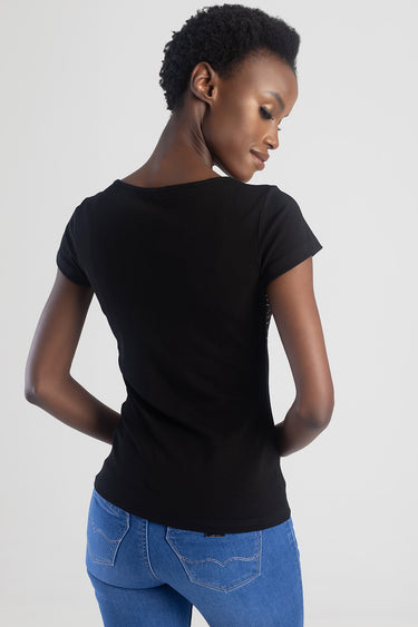 woman wearing a black short sleeve top and blue jeans, back view