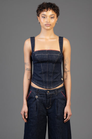 Blue Jean Traders denim top on a model, sleeveless corset style with red trim along the neckline, paired with dark denim
