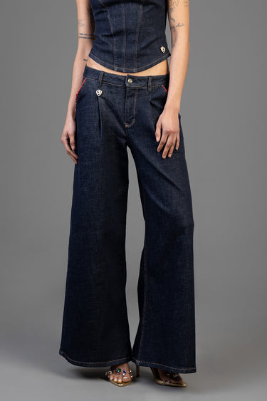 woman wearing dark denim wide leg jeans with heart charm on pocket and red stitching, high waist