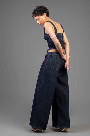 woman wearing dark indigo wide leg jeans and a cropped denim top with shoulder straps, shown from behind