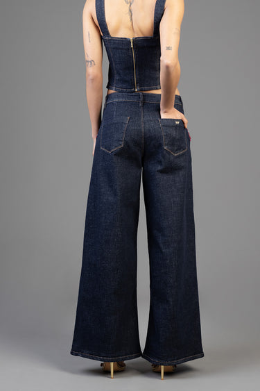 back view of a person in dark indigo wide leg jeans with back pockets and a cropped denim corset top