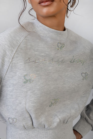 light grey sweatshirt with crystal rhinestone cursive lettering and small heart motifs across chest