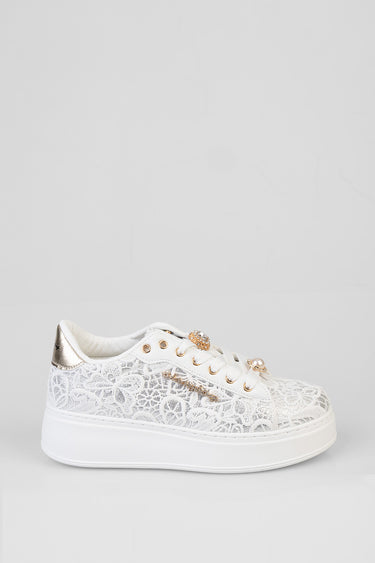white lace sneaker with gold metallic heel patch, gold eyelets, and decorative charms on the side over a chunky white sole
