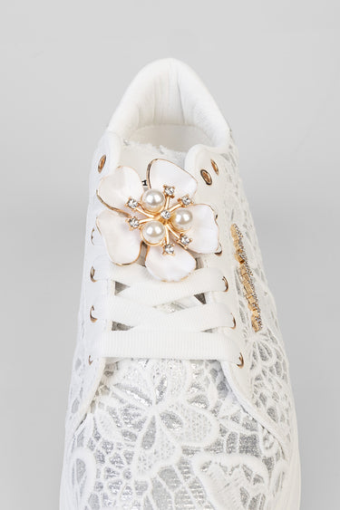 white lace sneakers by blue jean traders with a large pearl flower embellishment on the laces and gold accents