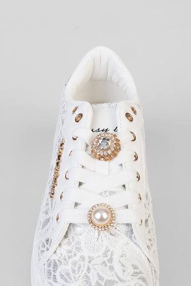 white lace sneakers with gold eyelets and a sparkling rhinestone brooch on the laces, plus a pearl accent