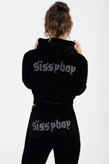 woman in black velvet tracksuit with rhinestone logo reading Sissy Boy on back and pants
