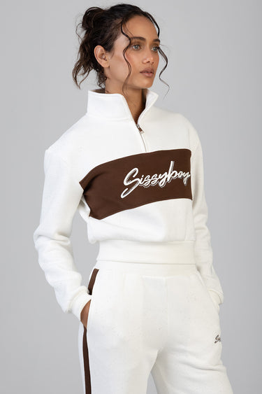 woman wearing white and brown colour-block zip top with high collar and matching white jogger pants