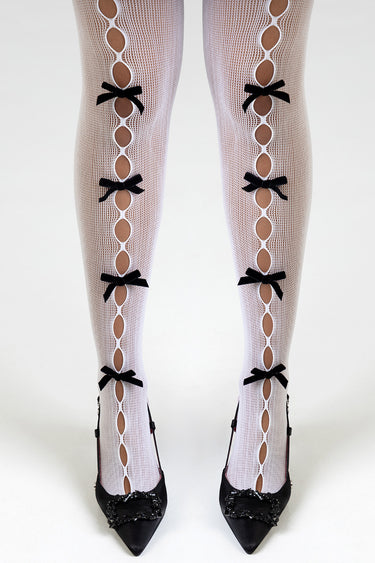 woman wearing white fishnet stockings with circular cutouts and black bows, paired with black heels