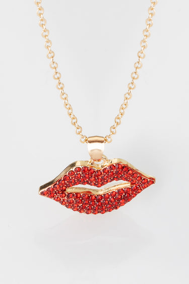 gold tone lip shaped pendant adorned with red stones on a gold chain