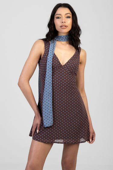 brown sleeveless mini dress with light blue polka dots, v neck, wrap bodice, and a matching light blue polka dot scarf