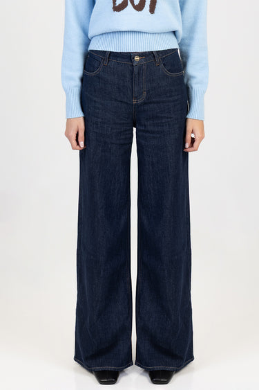 person wearing dark indigo wide leg jeans with contrast stitching and a light blue knit sweater