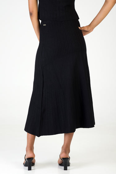 black ribbed knit midi skirt shown from behind with a small gold tag at the waist