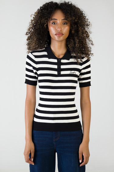 woman wearing black and white striped knit polo top with short sleeves and collar; small logo on chest.