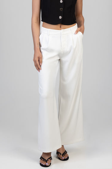 woman wearing white wide leg trousers with a high waist and front pleats paired with a black cropped top and sandals