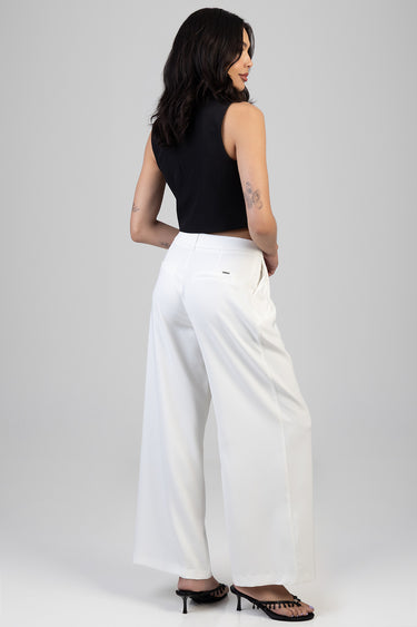woman wearing white wide leg trousers with a black sleeveless top, back view