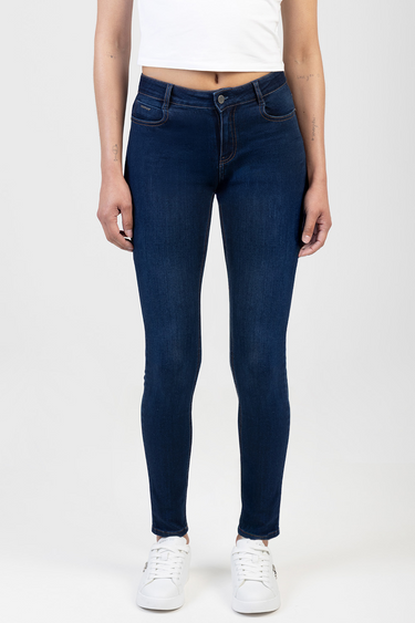 model wearing dark indigo skinny jeans by Blue Jean Traders with white sneakers