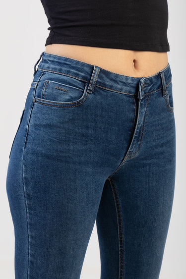 blue wash skinny jeans with belt loops and a zip fly, worn with a black crop top