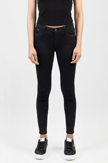 woman wearing black skinny jeans with a black top and black sneakers with white soles