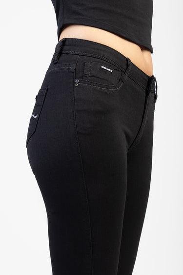black skinny jeans fitted on a model from the side, with belt loops, front pockets and a small brand label on the coin pocket