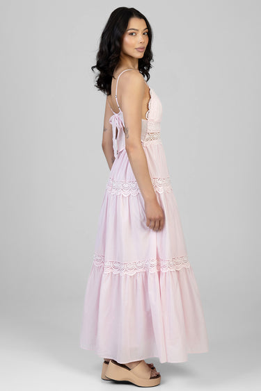 woman in pastel pink maxi dress with lace trim and back tie side view