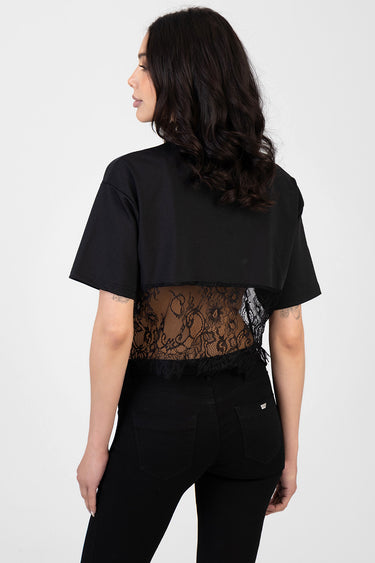 woman wears a black short sleeve top with a sheer lace back panel over black jeans