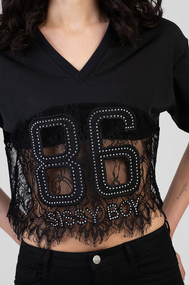 black boxy short sleeve top with a deep v neck and a sheer lace panel featuring large rhinestone bordered numerals across