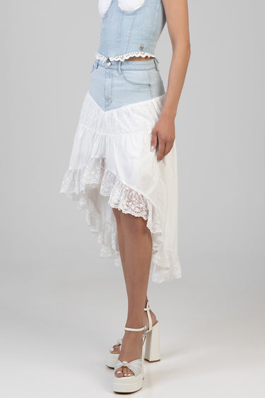 model wearing a light wash denim high low skirt with white eyelet lace trim and tiered white fabric, paired with white