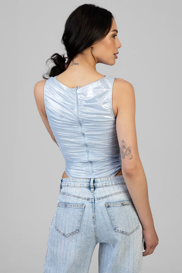 back view of a woman wearing a light blue ruched sleeveless top with a back zipper and denim jeans