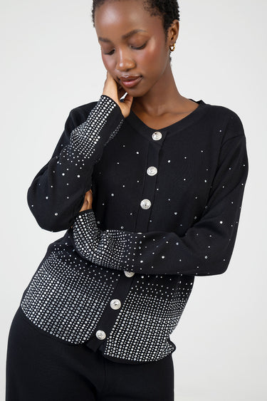 woman in black knit cardigan with silver studs along cuffs, hem, and front buttons