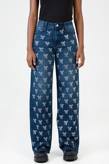 woman wearing blue wide leg jeans by Blue Jean Traders with white bow pattern and a black top