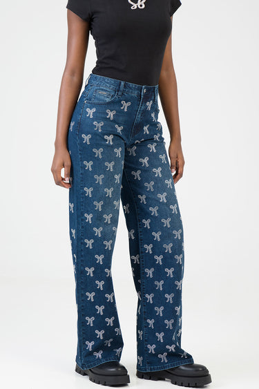 blue jean traders wide leg jeans with a white bow pattern worn by a model in a black t shirt and chunky black boots